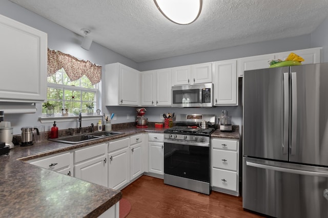373 Baronswood Dr, Nolensville, TN 37135 - kitchen featuring stainless steel appliances, a sink, dark countertops, a textured ceiling, and white cabinetry
