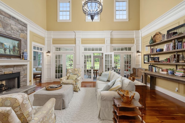 460 Whistler Cv, Franklin, TN 37067 - living area featuring a towering ceiling, french doors, a stone fireplace, wood finished floors, and plenty of natural light