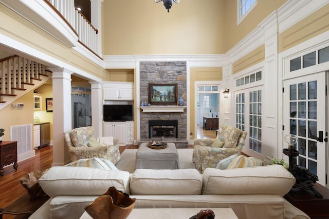 460 Whistler Cv, Franklin, TN 37067 - living room featuring a towering ceiling, a stone fireplace, wood finished floors, and ornate columns