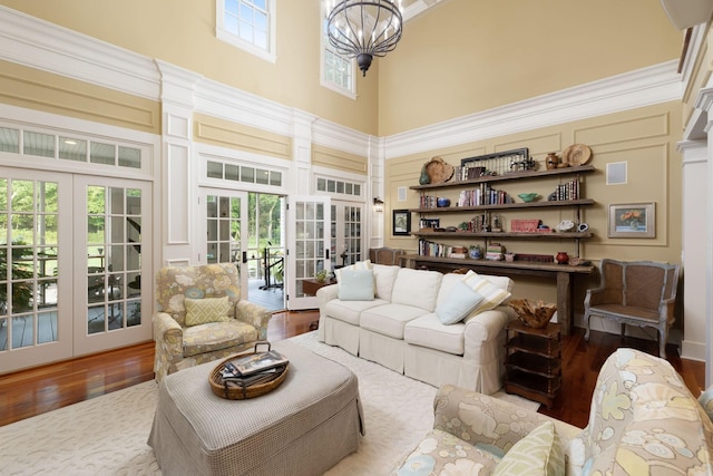 460 Whistler Cv, Franklin, TN 37067 - living room featuring french doors, a high ceiling, wood finished floors, a chandelier, and a decorative wall