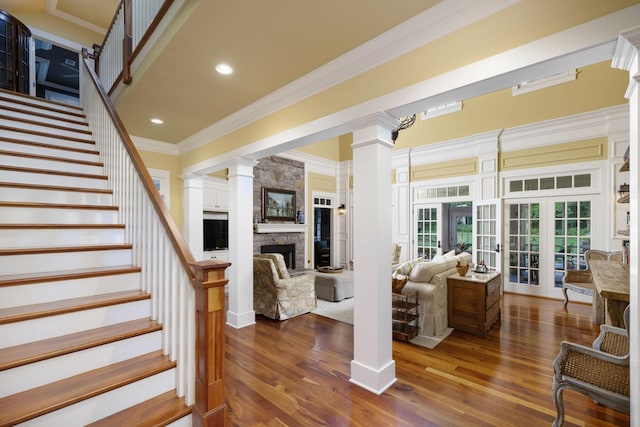 460 Whistler Cv, Franklin, TN 37067 - living room featuring decorative columns, crown molding, stairway, a stone fireplace, and dark wood-style flooring