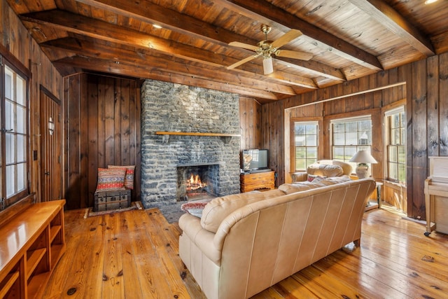 4430 Brush Hill Rd, Nashville, TN 37216 - living area featuring hardwood / wood-style floors, a stone fireplace, wood walls, wooden ceiling with exposed beams, and a ceiling fan