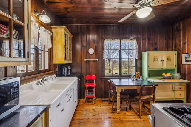 4430 Brush Hill Rd, Nashville, TN 37216 - kitchen featuring wood ceiling, stainless steel microwave, wood walls, hardwood / wood-style floors, and glass insert cabinets