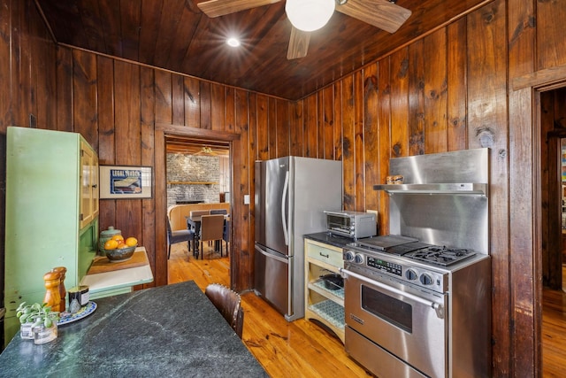 4430 Brush Hill Rd, Nashville, TN 37216 - kitchen with appliances with stainless steel finishes, under cabinet range hood, wood walls, wood ceiling, and light wood-type flooring