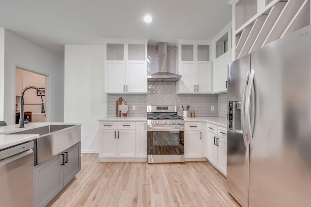 608 Claridge Ct, Franklin, TN 37064 - kitchen with appliances with stainless steel finishes, wall chimney exhaust hood, tasteful backsplash, light wood-style floors, and light countertops