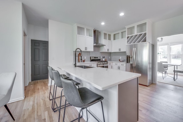 608 Claridge Ct, Franklin, TN 37064 - kitchen with stainless steel appliances, wall chimney range hood, a sink, a peninsula, and a breakfast bar