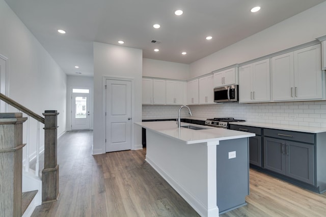 529 Little Penny Dr, Smyrna, TN 37167 - kitchen with appliances with stainless steel finishes, gray cabinets, tasteful backsplash, light wood-type flooring, and recessed lighting