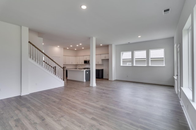 529 Little Penny Dr, Smyrna, TN 37167 - unfurnished living room with recessed lighting, stairs, and light wood-style flooring