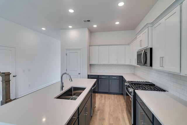 529 Little Penny Dr, Smyrna, TN 37167 - kitchen featuring appliances with stainless steel finishes, light countertops, decorative backsplash, light wood finished floors, and recessed lighting