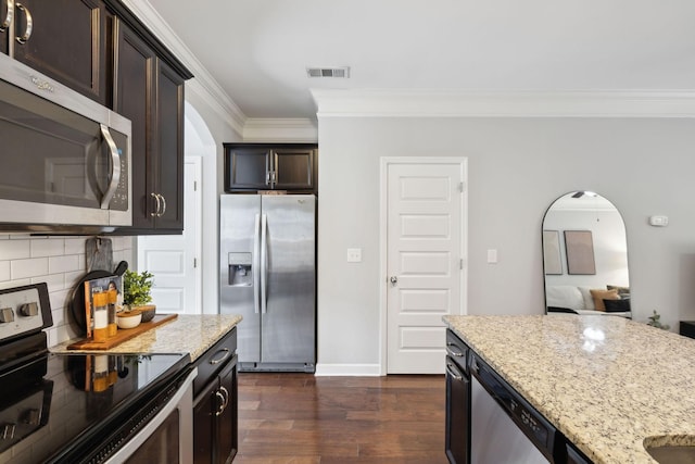 212 Walden Village Ln, Nashville, TN 37210 - kitchen featuring appliances with stainless steel finishes, crown molding, arched walkways, light stone countertops, and dark wood-style flooring