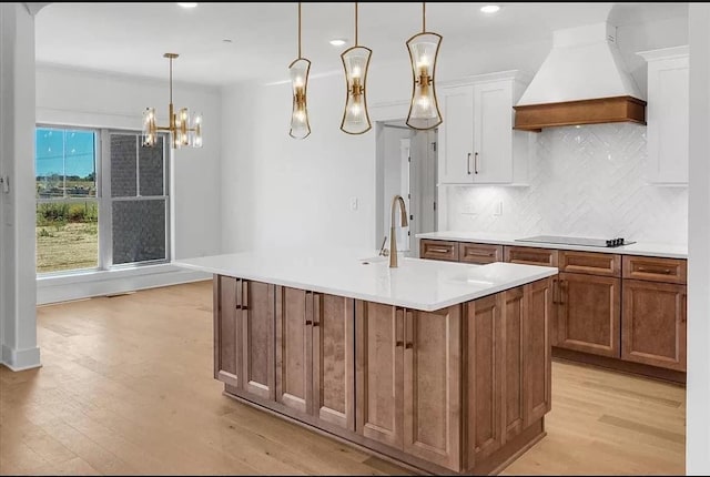 691 Compton Rd, Murfreesboro, TN 37130 - kitchen featuring premium range hood, black electric stovetop, light wood-type flooring, white cabinets, and light countertops