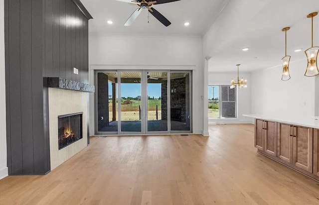 691 Compton Rd, Murfreesboro, TN 37130 - unfurnished living room featuring light wood-type flooring, a large fireplace, ceiling fan, a chandelier, and baseboards