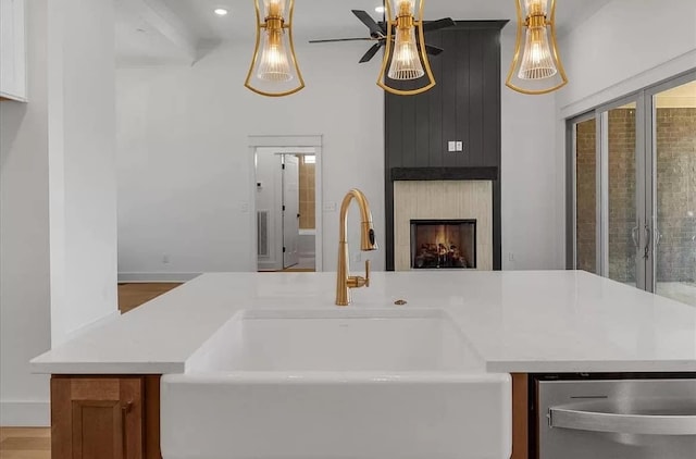 691 Compton Rd, Murfreesboro, TN 37130 - kitchen featuring a sink, stainless steel dishwasher, light countertops, ceiling fan, and a large fireplace
