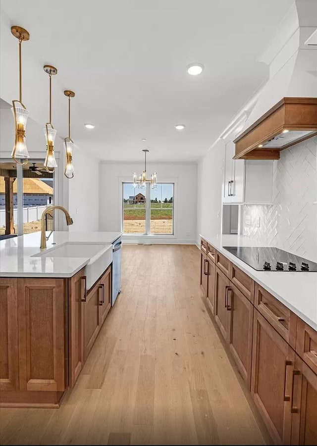 691 Compton Rd, Murfreesboro, TN 37130 - kitchen with a sink, premium range hood, brown cabinets, a chandelier, and light wood-style floors