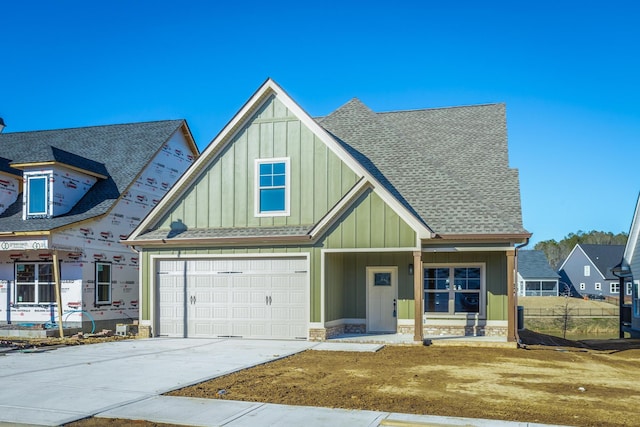 516 Willow Grv Ct, Ringgold, GA 30736 - view of front of house featuring board and batten siding, roof with shingles, driveway, a garage, and covered porch