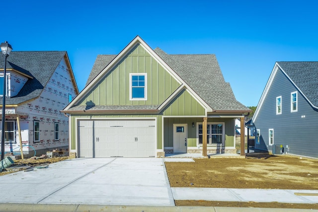 516 Willow Grv Ct, Ringgold, GA 30736 - view of front facade with board and batten siding, a shingled roof, an attached garage, and concrete driveway