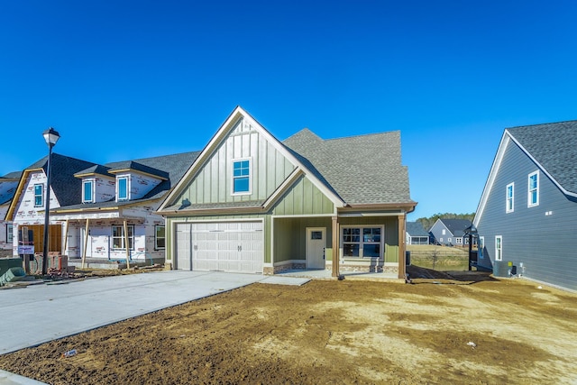 516 Willow Grv Ct, Ringgold, GA 30736 - view of front of property featuring board and batten siding, driveway, central air condition unit, an attached garage, and roof with shingles