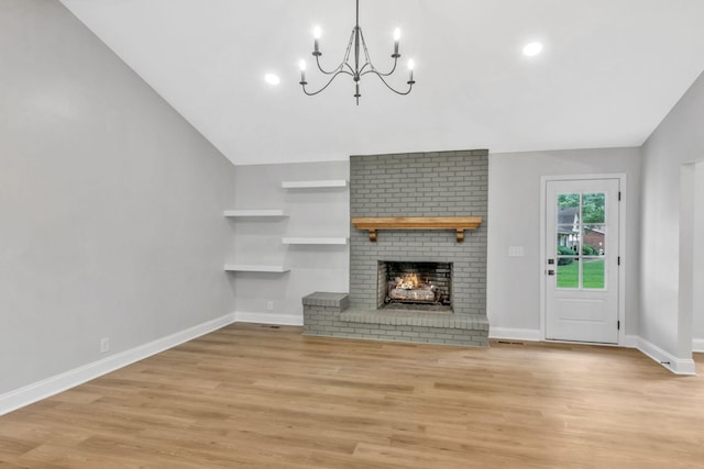 2302 Surrey Dr, Murfreesboro, TN 37129 - unfurnished living room with a chandelier, light wood finished floors, a brick fireplace, vaulted ceiling, and baseboards