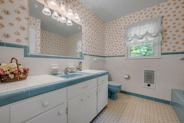 311 Broadview Dr, Dickson, TN 37055 - bathroom featuring wallpapered walls, heating unit, tile walls, vanity, and a wainscoted wall