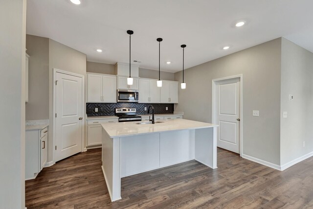 1012 Indigo Aly, Brentwood, TN 37027 - kitchen featuring stainless steel appliances, a sink, tasteful backsplash, dark wood finished floors, and a kitchen island with sink