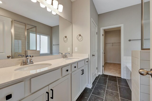 1012 Indigo Aly, Brentwood, TN 37027 - full bathroom with marble finish flooring, double vanity, a bath, a walk in closet, and baseboards