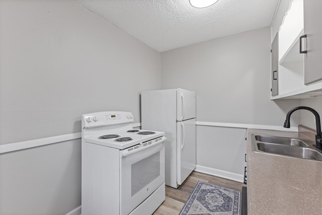 276 White Bridge Pike Unit 70, Nashville, TN 37209 - kitchen featuring white appliances, a sink, light wood-style flooring, a textured ceiling, and baseboards