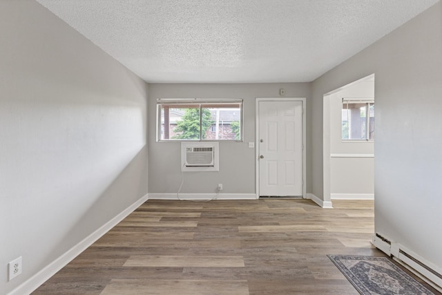 276 White Bridge Pike Unit 70, Nashville, TN 37209 - foyer featuring a baseboard heating unit, a textured ceiling, a wall unit AC, wood finished floors, and baseboards