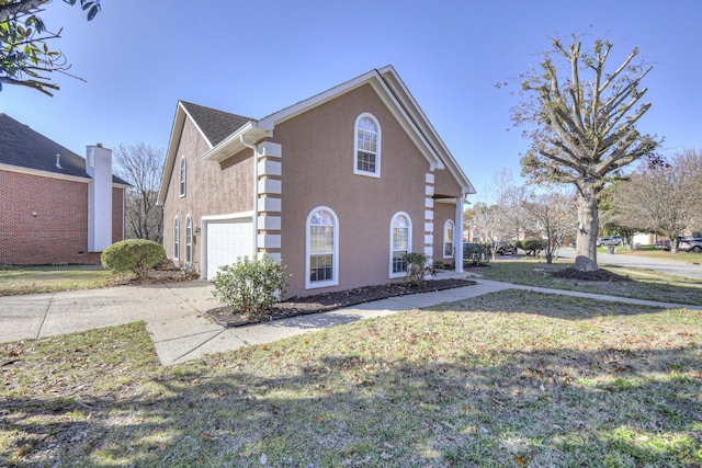 3117 Harborwood Dr, Nashville, TN 37214 - view of side of property with stucco siding, a garage, concrete driveway, and a lawn
