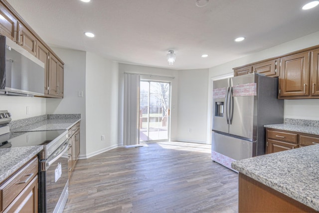 3117 Harborwood Dr, Nashville, TN 37214 - kitchen featuring stainless steel appliances, light wood-style floors, baseboards, recessed lighting, and brown cabinets