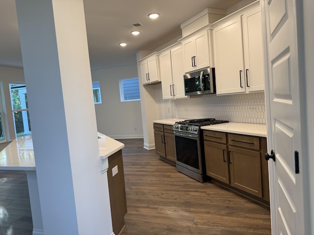 1279 Linn Cove Ct, Gallatin, TN 37066 - kitchen featuring appliances with stainless steel finishes, decorative backsplash, light countertops, dark wood-type flooring, and baseboards