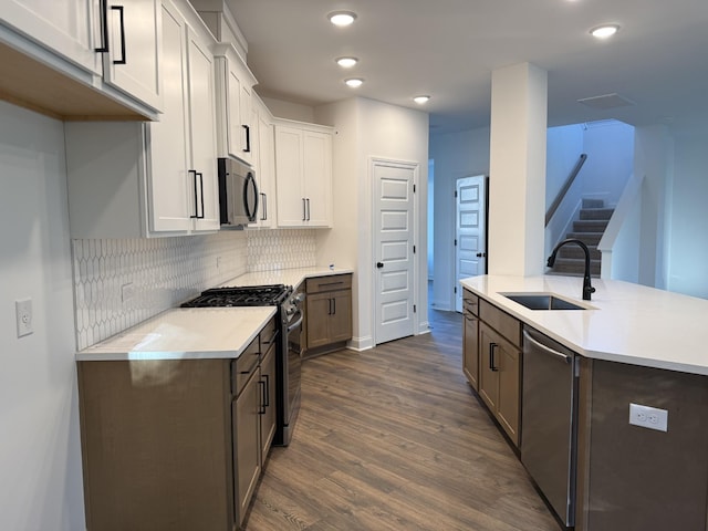 1279 Linn Cove Ct, Gallatin, TN 37066 - kitchen featuring a sink, stainless steel appliances, dark wood-style flooring, light countertops, and backsplash