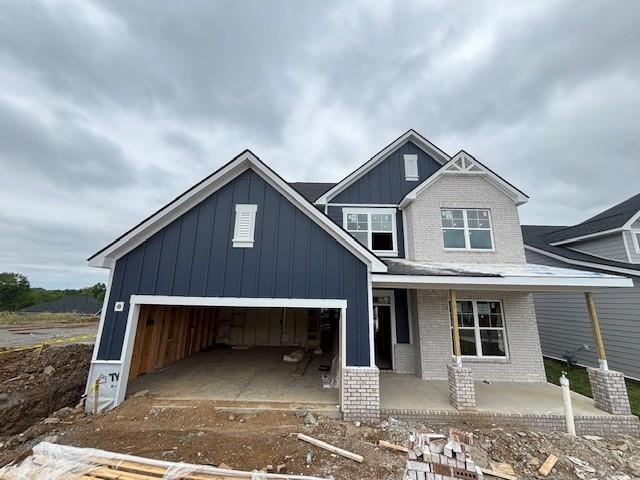 1102 Callaway Dr, Lebanon, TN 37087 - view of front of home with board and batten siding, covered porch, brick siding, and an attached garage