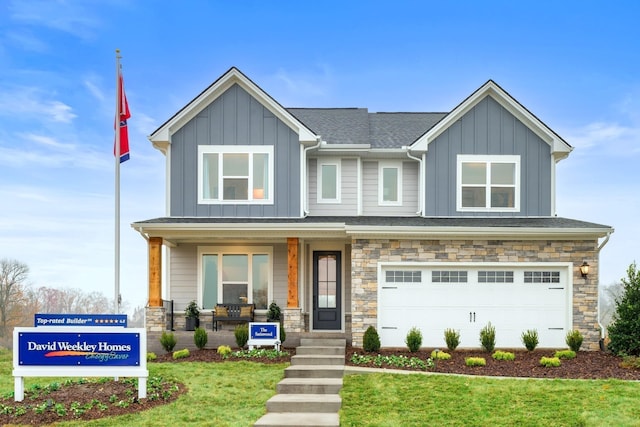 1102 Callaway Dr, Lebanon, TN 37087 - view of front facade with board and batten siding, covered porch, a front yard, stone siding, and an attached garage