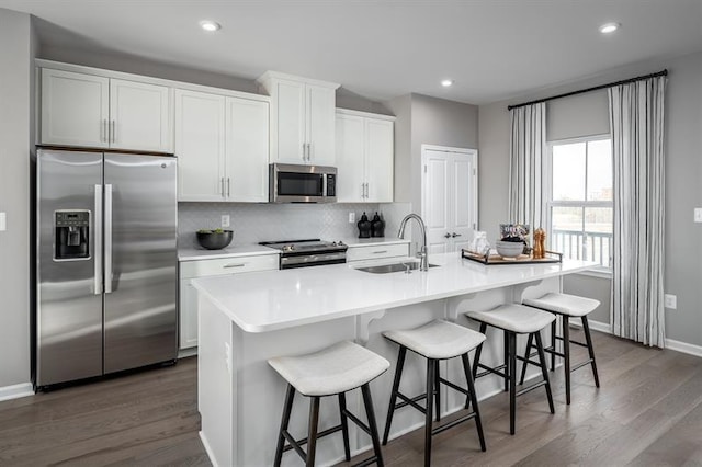 4038 Gaskill Dr Unit 113B, Smyrna, TN 37167 - kitchen with stainless steel appliances, a sink, backsplash, dark wood-style flooring, and an island with sink
