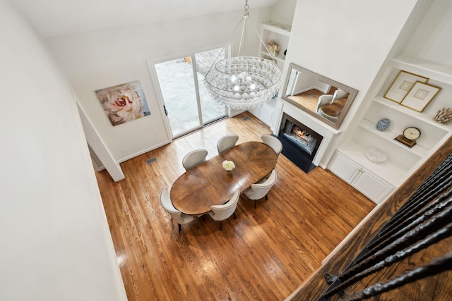 327 Whitworth Way, Nashville, TN 37205 - living room featuring wood finished floors, built in shelves, a fireplace with flush hearth, a chandelier, and baseboards