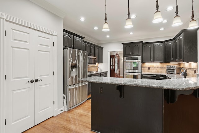 1010 Saint Blaise Trl, Gallatin, TN 37066 - kitchen featuring appliances with stainless steel finishes, ornamental molding, a kitchen breakfast bar, tasteful backsplash, and light wood-style flooring