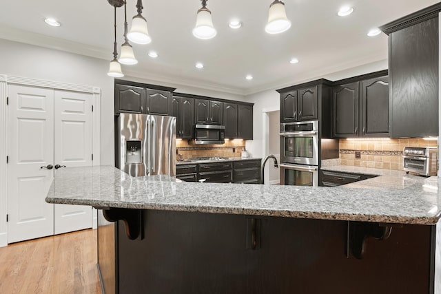 1010 Saint Blaise Trl, Gallatin, TN 37066 - kitchen featuring stainless steel appliances, a breakfast bar, decorative backsplash, light stone counters, and crown molding