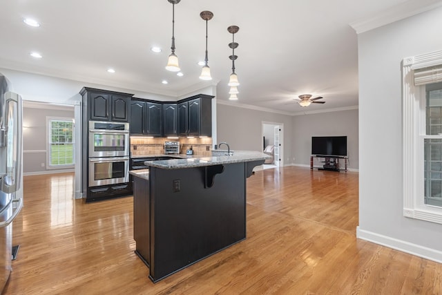1010 Saint Blaise Trl, Gallatin, TN 37066 - kitchen featuring appliances with stainless steel finishes, a kitchen breakfast bar, a peninsula, baseboards, and stone counters
