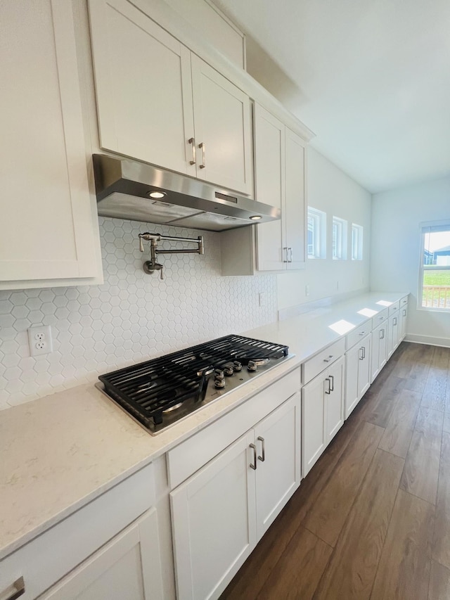 310 Carver Ln, Lebanon, TN 37087 - kitchen featuring under cabinet range hood, stainless steel gas cooktop, dark wood-style flooring, backsplash, and white cabinets