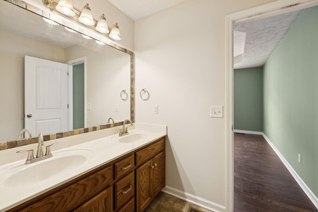 1006 Aretha Dr, Murfreesboro, TN 37128 - bathroom with double vanity, baseboards, a textured ceiling, and wood finished floors