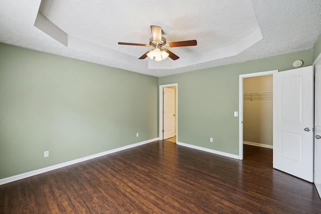 1006 Aretha Dr, Murfreesboro, TN 37128 - unfurnished bedroom featuring a tray ceiling, a textured ceiling, wood finished floors, baseboards, and a spacious closet