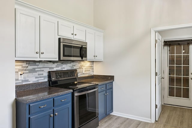 1006 Aretha Dr, Murfreesboro, TN 37128 - kitchen featuring stainless steel appliances, blue cabinetry, dark countertops, and white cabinetry