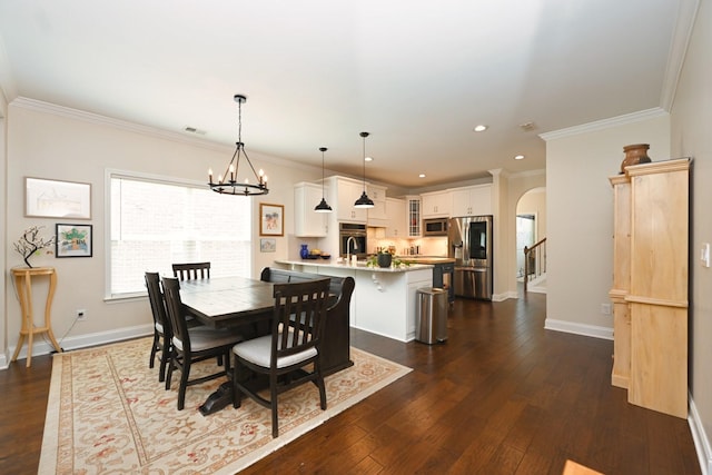 146 Monarchos Dr, Gallatin, TN 37066 - dining room with arched walkways, a chandelier, crown molding, dark wood-type flooring, and baseboards