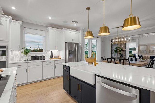 1069 Sycamore Ests, Nashville, TN 37211 - kitchen with stainless steel appliances, a sink, white cabinets, crown molding, and tasteful backsplash