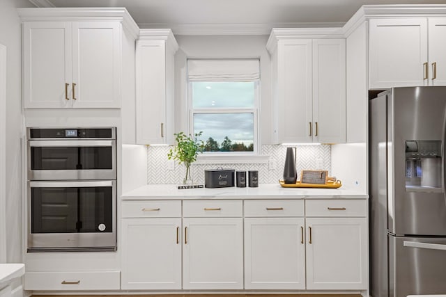 1069 Sycamore Ests, Nashville, TN 37211 - kitchen with appliances with stainless steel finishes, white cabinetry, tasteful backsplash, and ornamental molding