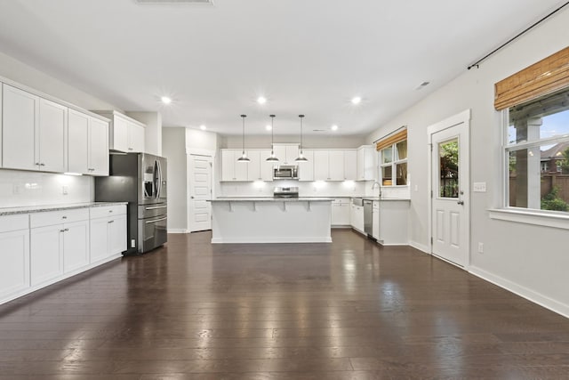 3368 Vinemont Dr, Thompsons Station, TN 37179 - kitchen with appliances with stainless steel finishes, a breakfast bar, white cabinetry, and recessed lighting
