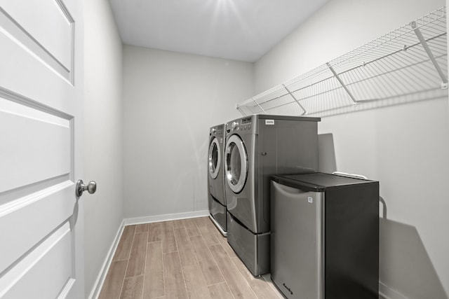 3368 Vinemont Dr, Thompsons Station, TN 37179 - laundry room with independent washer and dryer, light wood-style floors, and baseboards
