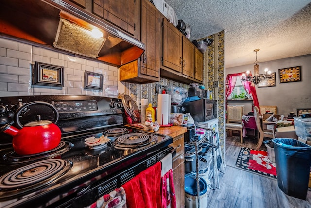 3846 Saunders Ave, Nashville, TN 37216 - kitchen with electric range, under cabinet range hood, a textured ceiling, wood finished floors, and stainless steel microwave