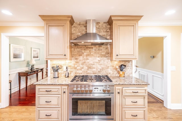 1234 Windsor Dr, Gallatin, TN 37066 - kitchen with stainless steel stove, wall chimney exhaust hood, cream cabinets, light stone countertops, and light wood-style floors
