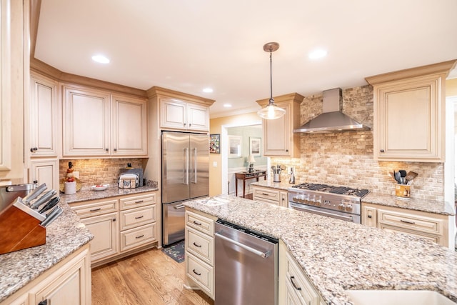 1234 Windsor Dr, Gallatin, TN 37066 - kitchen featuring high end appliances, wall chimney exhaust hood, cream cabinetry, tasteful backsplash, and light stone counters